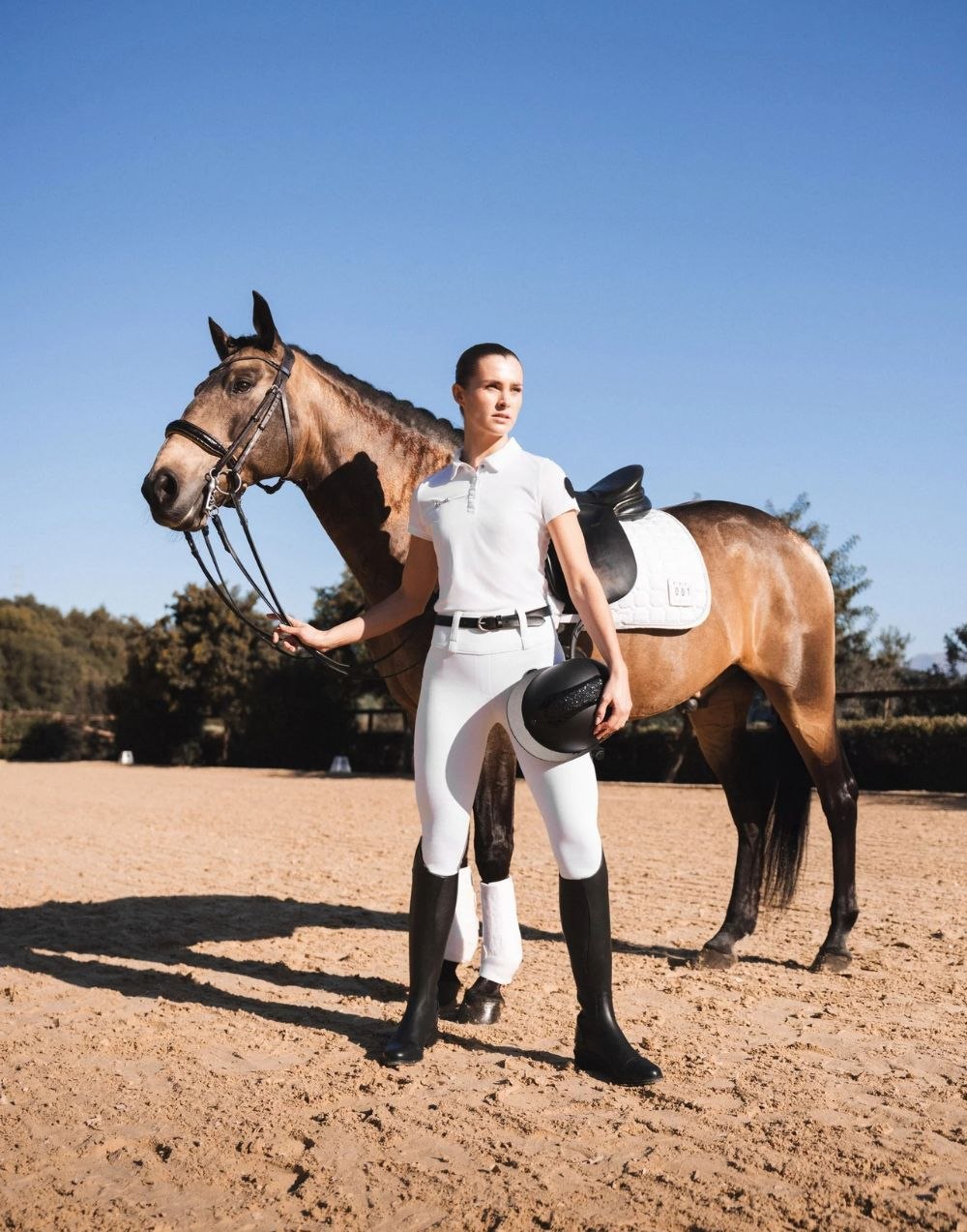 Rider in white competition breeches with buckskin horse